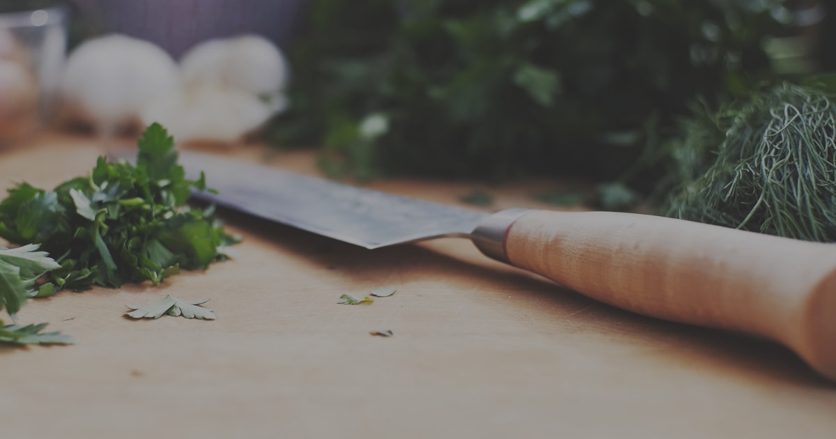 Kochmesser auf Schneidbrett mit Kräutern — Unterweisungen für Gastronomie und Küche