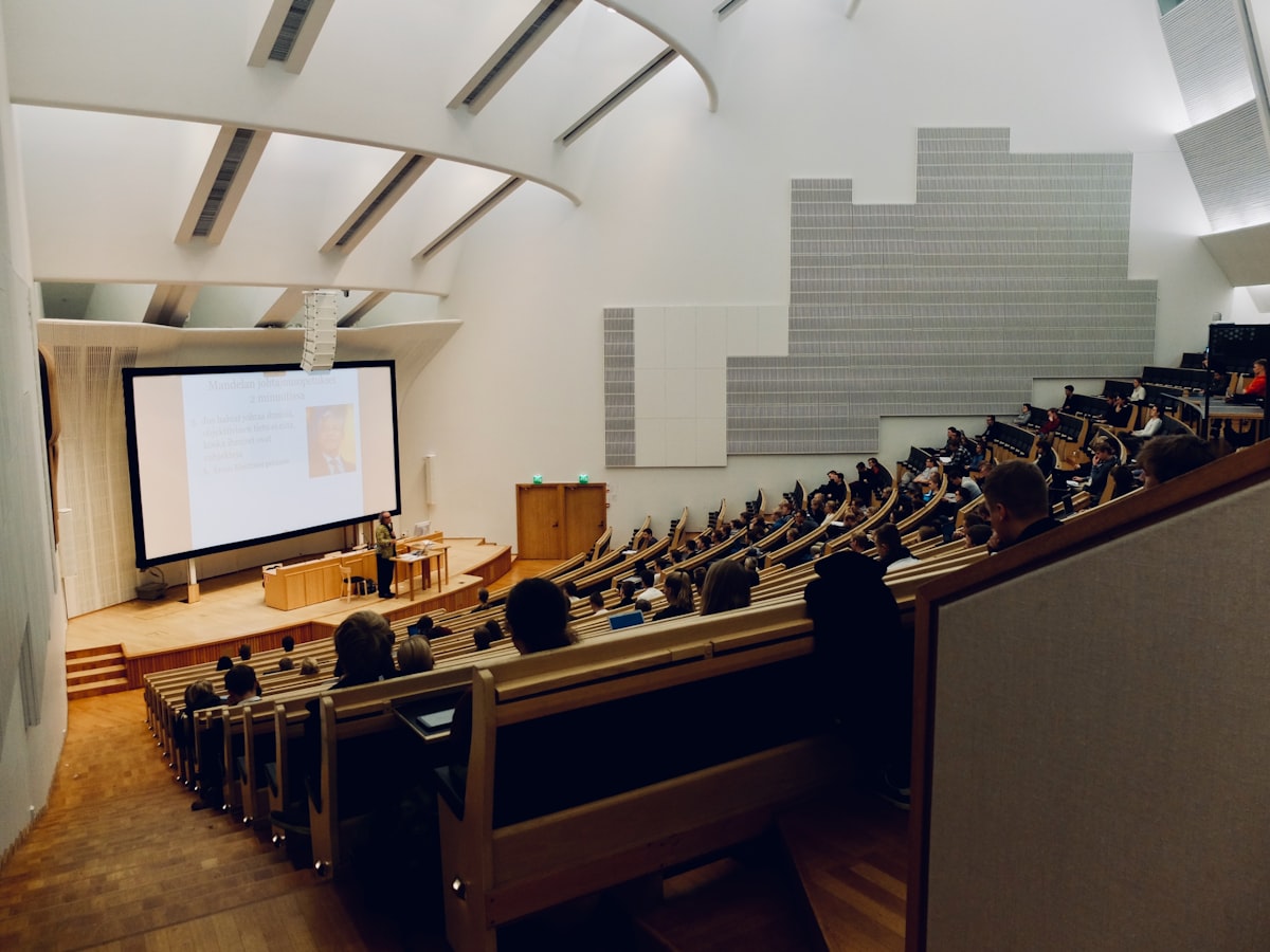 Hörsaal mit Online-Lernumgebung auf der Leinwand – Sinnbild für strukturierte Mitarbeiter-Schulung
